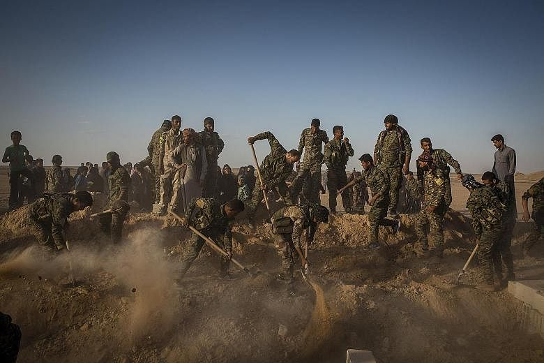 Members of the Syrian Democratic Forces (SDF) burying a comrade, who died fighting to oust ISIS militants from Raqqa, in the nearby village of Hukumya, Syria, last week. A lightning final assault on Tuesday saw the SDF claim a landmark victory in the