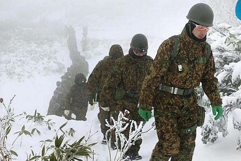 About 130 personnel from the Hokkaido police force's mountain rescue team (top) and from the military Ground Self-Defence Force (above) were reported to be involved in the successful search operation. The hikers were found 22 hours after they made a 