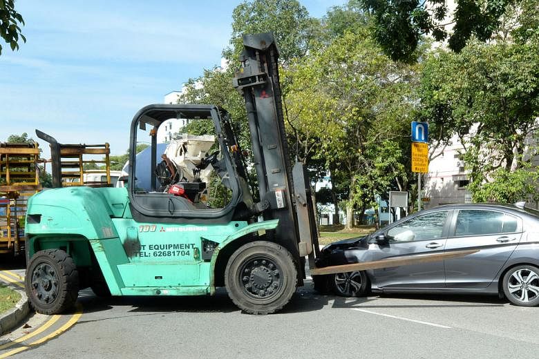 Above: The forklift was being driven onto a lorry outside an army camp when it hit the car.