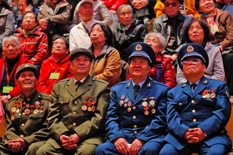 War veterans and residents watching a broadcast of the opening of the CCP congress at a bookstore in Shenyang, China's Liaoning province, yesterday. President Xi Jinping's nearly 31/2 hour speech was also keenly followed by global watchers for a sens