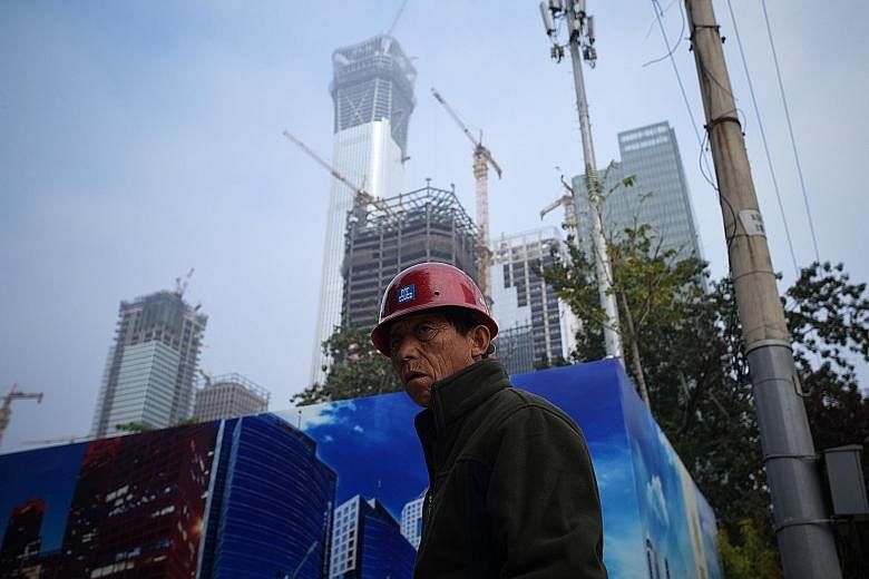 A worker outside a construction site in Beijing's Central Business District on Tuesday. New construction starts by floor area in China rose just 1.4 per cent on the year last month, slowing from a 5.3 per cent increase in August.