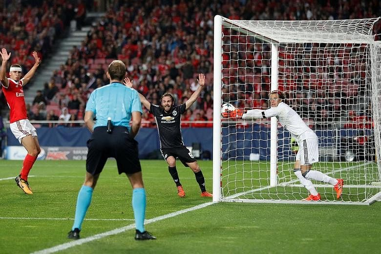 Benfica's 18-year-old goalkeeper Mile Svilar carrying the ball over the line despite stopping a free kick by Marcus Rashford (not pictured). The error gave Manchester United a 1-0 win in the Champions League Group A game.