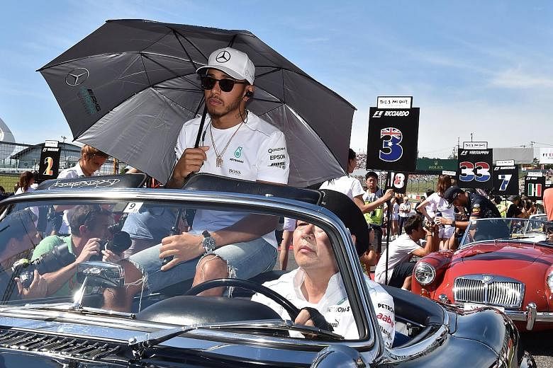 Mercedes' F1 leader Lewis Hamilton during the classic car parade before the Japanese GP, where rival Sebastian Vettel was forced to retire.