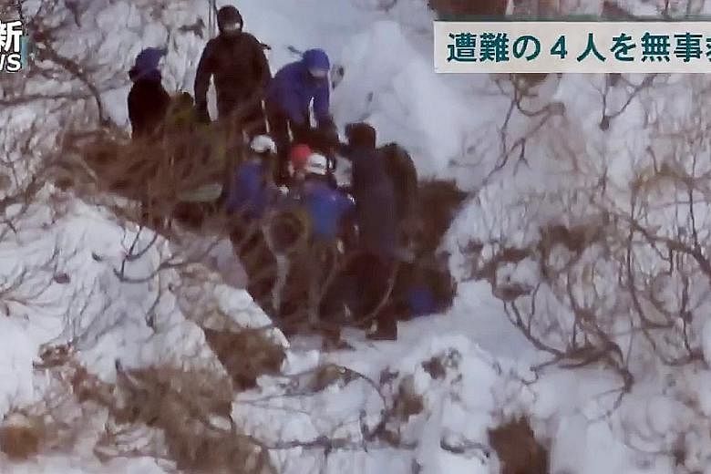 Rescuers are seen in a video grab with the four stranded hikers, including Singaporean Amelda Lim and her Malaysian husband Long Ji Yung, as they get ready to be airlifted from Asahidake early Wednesday morning.