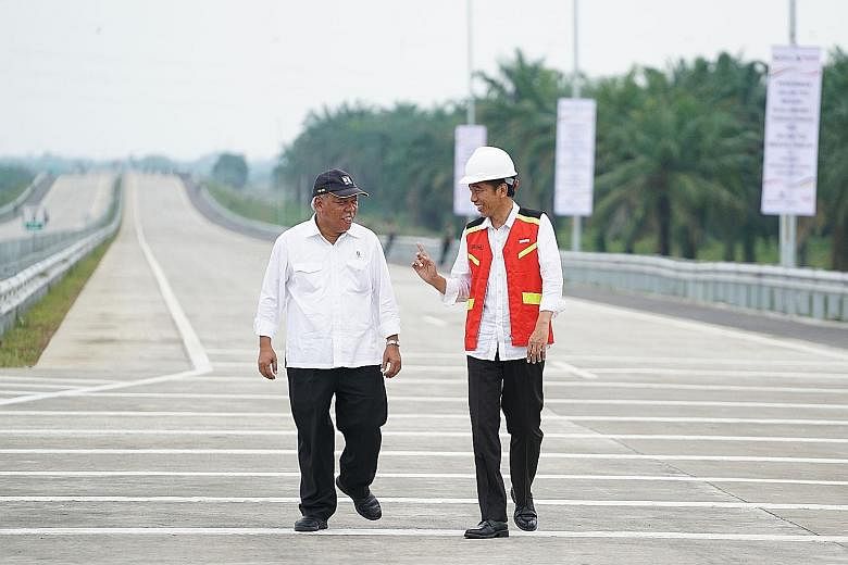 Indonesia's President Joko Widodo (right) speaking with Minister of Public Works and Housing Basuki Hadimuljono during the inauguration of the Medan-Kualanamu-Tebing Tinggi toll road last Friday.