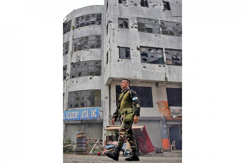 A soldier walking past a building in Marawi city that was damaged after troops cleared the area of pro-ISIS militant groups yesterday.