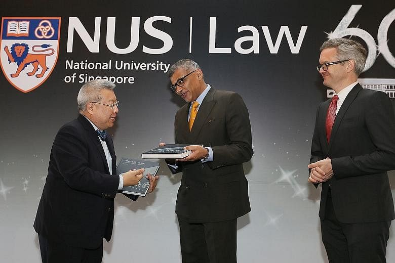 Legal historian Kevin Tan presenting a copy of his new book, The Lamp Of The Law: 60 Years Of Legal Education At NUS Law, to Chief Justice Sundaresh Menon, with NUS law dean Simon Chesterman looking on. They were at the 60th anniversary gala of the N