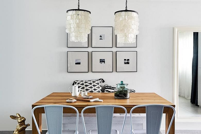The dining area gets a rustic touch with a wooden table and pendant lamps made of seashells.