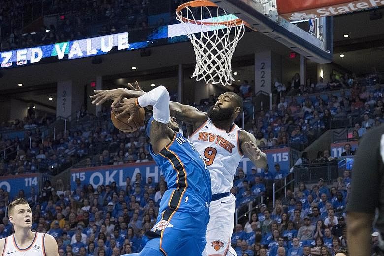 New York Knicks' Kyle O'Quinn (in white) trying to block Carmelo Anthony of the Oklahoma City Thunder during their NBA game on Thursday. Anthony ended with 22 points in his team's 105-84 victory.