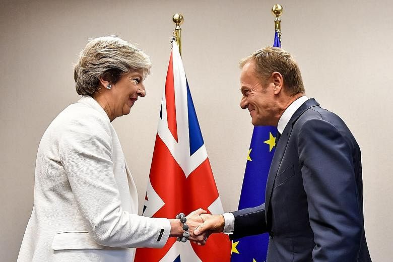 British Prime Minister Theresa May being welcomed by European Council President Donald Tusk for a bilateral meeting in Brussels yesterday. In a move that risks being seen as a snub to the EU's gesture, Mrs May insisted once again yesterday that a det