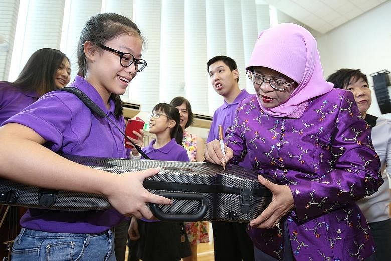 Dressed in purple, President Halimah Yacob signed autographs and chatted with over 60 musicians of the Purple Symphony yesterday, to encourage them as they prepared for an upcoming concert. The musicians, some of whom have special needs, will be perf