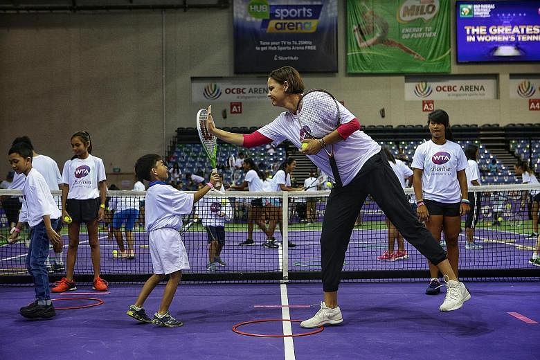 WTA Finals ambassador Lindsay Davenport, a three-time Grand Slam singles champion, high-fiving Adam Sharin, who took part in the WTA Charities Community Day at OCBC Arena yesterday.