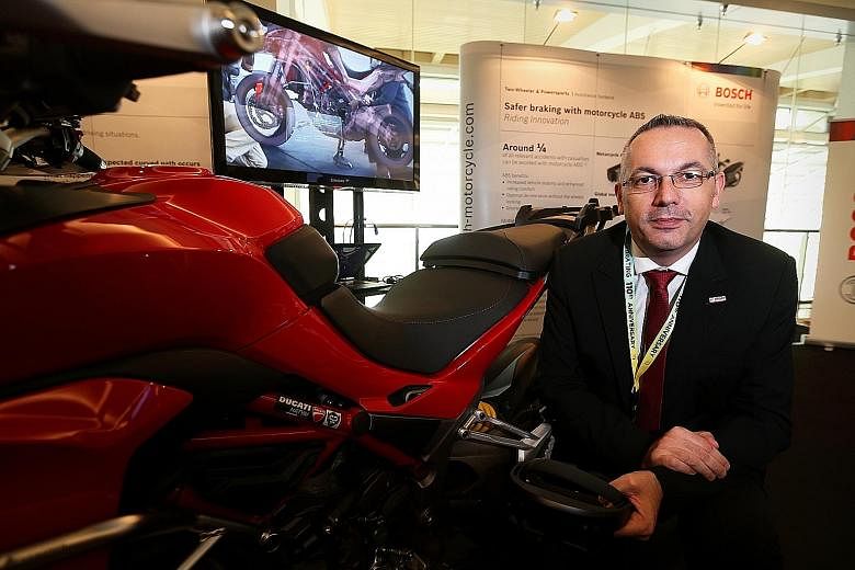 Mr Klaus Landhaeusser at a display showing how virtual reality and augmented reality can help mechanics and technicians learn about the systems used in motorcycles like the Ducati Multistrada above. In the background is an X-ray model of the Ducati b