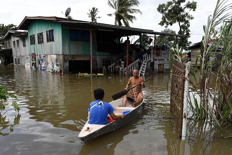 Villagers of Kampung Taun Gusi in Kota Belud making their way home in a sampan after four days of continuous heavy rain. Many areas in Sabah are flooded, with Kota Belud being the worst hit.