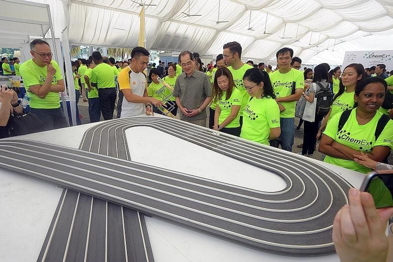 Mr Lim Hng Kiang (in grey) at a Shell electric car exhibit on Saturday at ChemEx, an annual event organised to raise awareness of career opportunities in the energy and chemicals industry.