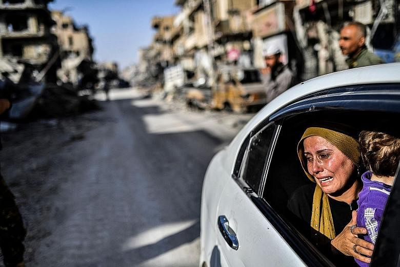 A woman cries while being driven through Raqqa last Friday, after a Kurdish-led force expelled ISIS militants from the northern Syrian city. The fall of Raqqa and the defeat of militants in Marawi might have dealt a major blow to ISIS, but Asian capi