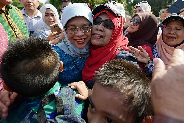 Above: President Halimah Yacob with Marsiling resident Jainah Awang, 68, one of about 80 residents from Marsiling-Yew Tee GRC whom the President met at the Istana open house yesterday. Madam Halimah was an MP in the GRC before she resigned to run for