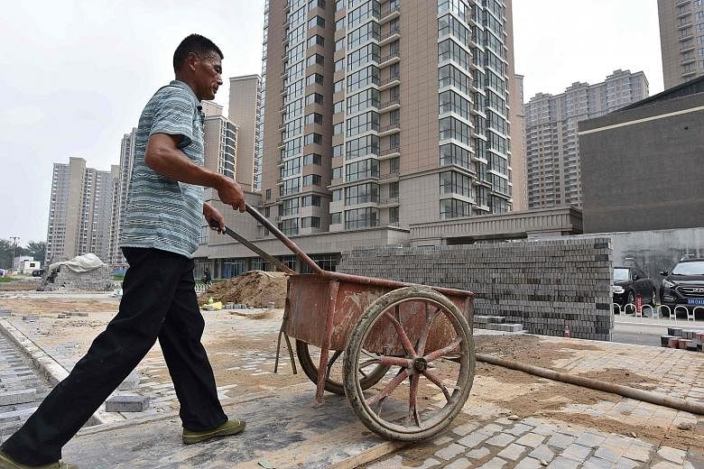 Chinese Housing Minister Wang Menghui (above) says Beijing will not waver in its efforts to regulate the property market and has no intention of loosening control measures, in a sign that the housing market is still being closely watched. Right: A wo