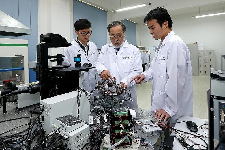 Japanese robotics expert Toshio Fukuda (centre) with two Chinese students at the Beijing Institute of Technology. A Forbes report says more Chinese who studied or worked overseas are returning home. Experts in the science and technology sector have m