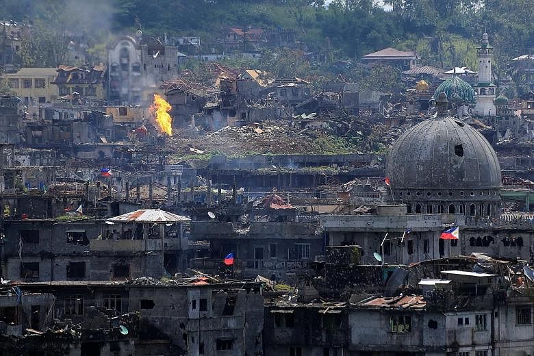 Damaged buildings in war-torn Marawi City after government troops cleared the last area of pro-ISIS militants yesterday. More than 1,000 militants, government troops and civilians have been killed in the conflict which began on May 23.