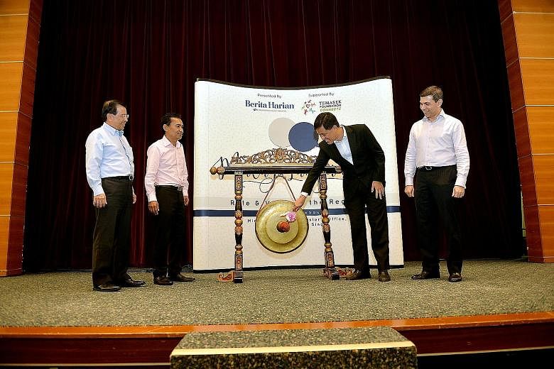 Mr Chan Chun Sing hitting a gong to open the BH forum at the SPH News Centre Auditorium yesterday. With him are (from left) Temasek Foundation Connects chief executive Lim Hock Chuan, BH editor Saat Abdul Rahman and SPH English/Malay/Tamil Media Grou