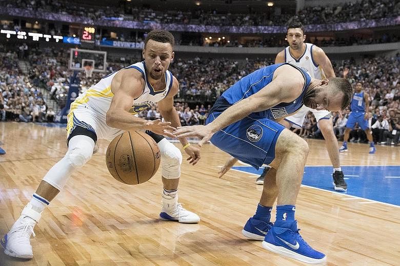 Golden State Warriors guard Stephen Curry stealing the ball from Dallas Mavericks' J.J. Barea. The champions have a 2-2 record this season.