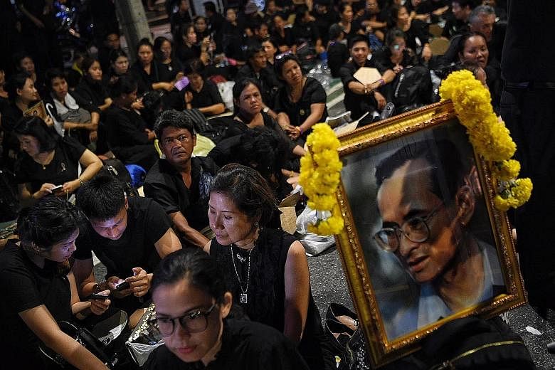 People queueing along Phra Athit Road yesterday to enter the area around Sanam Luang in Bangkok, where the royal funeral procession for the late King Bhumibol Adulyadej will take place. Many have been waiting for days to see this rare ceremony up clo