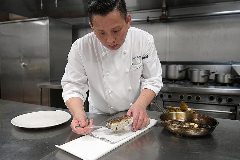 MBS executive chef Dave Heng (above) preparing a dish of sea bass. MBS is targeting that by 2020, half of all seafood items on the menus at its hotel and nine restaurants, including db Bistro (below), will be from sustainable sources.