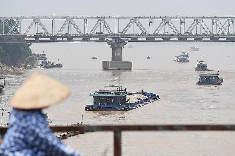 Boats on Hanoi's Red River transporting sand in August. Vietnam needs about 100 million cubic metres of sand every year for construction projects. With over-exploitation threatening to deplete the domestic supply of natural sand, the authorities are 