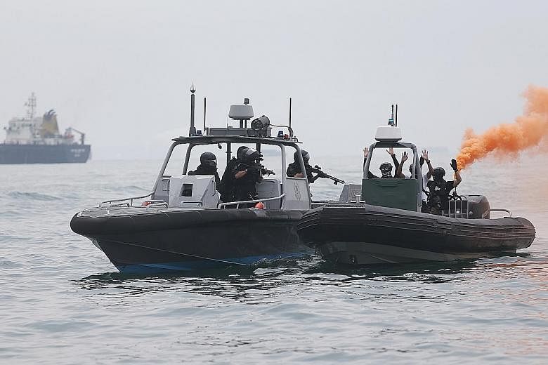 A Republic of Singapore Navy Littoral Mission Vessel (background, far left), and the Police Coast Guard's patrol interdiction boat (at right) intercepting the mock terrorists' speedboat. The exercise scenario involved "terrorists" in speedboats, who 