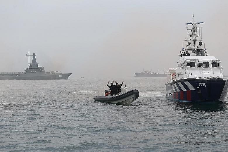 A Republic of Singapore Navy Littoral Mission Vessel (background, far left), and the Police Coast Guard's patrol interdiction boat (at right) intercepting the mock terrorists' speedboat. The exercise scenario involved "terrorists" in speedboats, who 