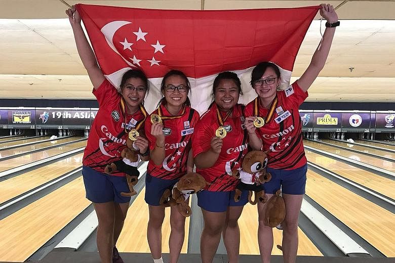 From left: Jermaine Seah, Charlene Lim, Illiya Syamim and Amabel Chua fly the Singapore flag high on the Coronado Lanes alleys in Manila after capturing a much-coveted team gold.