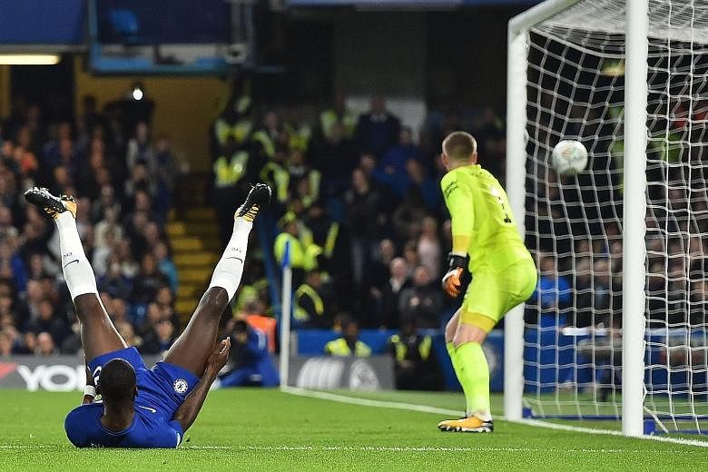 Chelsea's German defender Antonio Rudiger falls on his back after looping a header past Everton goalkeeper Jordan Pickford during their League Cup fourth-round match. Rudiger's goal set Chelsea on course for an eventual 2-1 victory.