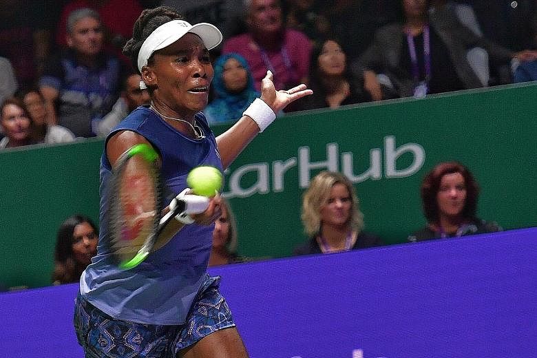 Venus Williams hitting a laboured return to Garbine Muguruza in their White Group match last night. The American came through in straight sets to seal her place in the last four as group runner-up.