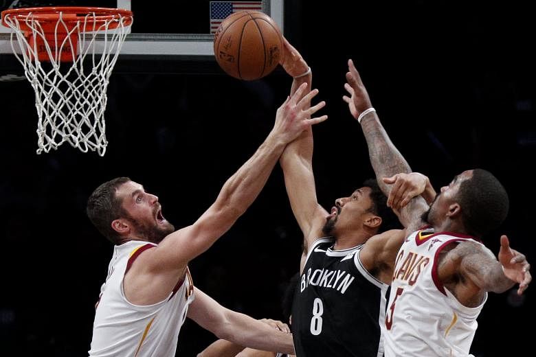 The Nets' Spencer Dinwiddie (No. 8) attempts a basket amid the close attention of the Cavaliers' Kevin Love (left) and J.R. Smith. Dinwiddie hit Brooklyn's go-ahead three as Cleveland conceded 17 three-pointers for the third game in succession.