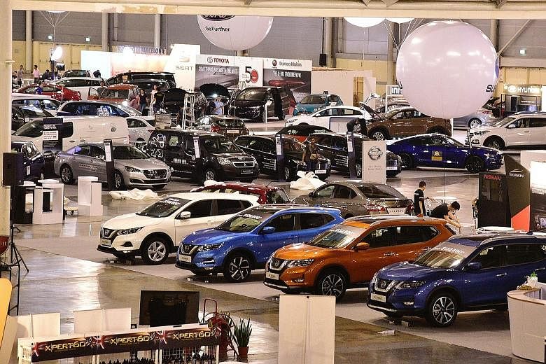 Workers setting up displays on the eve of Cars@Expo, SPH's two-day auto retail bazaar, which starts today. A wide range of sedans, sport utility vehicles, luxury cars and hybrid vehicles are for sale.
