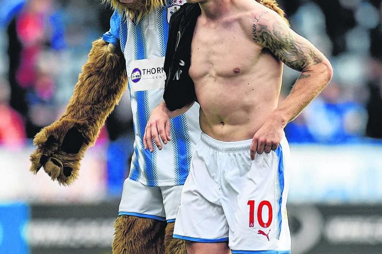 Huddersfield's Aaron Mooy celebrating with the club's mascot after their 1-1 draw with Leicester last month. Liverpool can ill afford to give the 27-year-old Australian space to roam in midfield.