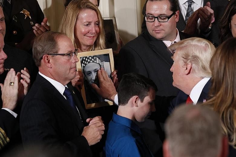 President Donald Trump meeting family members of an opioid victim after he declared the crisis a public health emergency on Thursday. He will redirect federal resources and loosen rules to combat opioid abuse, officials said, but the declaration does