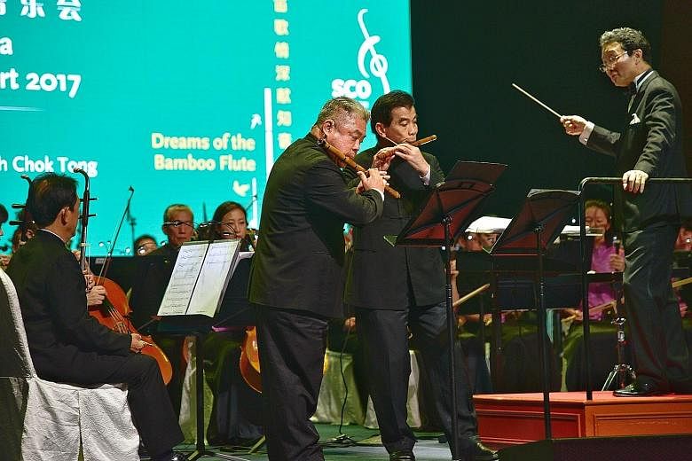 Musicians (standing from far left) Phang Thean Siong and Lim Sin Yeo playing the dizi while music director Tsung Yeh conducts the Singapore Chinese Orchestra at the gala event yesterday.