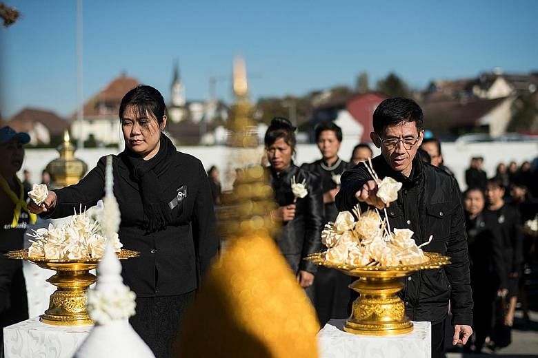 A mourner laying flowers for King Bhumibol Adulyadej at a Buddhist temple in Gretzenbach, Switzerland, on Thursday.