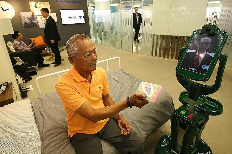 Mr Rasip Bin Sajak, 82, interacting with a robot at TUV SUD's new Smart Elderly Care @ Home Centre.