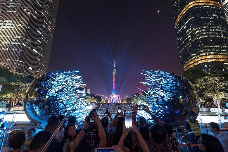 People taking pictures of the illuminated Guangzhou TV Tower in the capital of Guangdong province on Friday, when the 2017 Guangzhou International Light Festival kicked off, sparking much excitement and fanfare among visitors. This year's highly anti