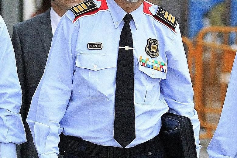 Mr Josep Lluis Trapero, the highest-ranking officer of the Mossos d'Esquadra regional police. Sacked Catalan president Carles Puigdemont and his wife Marcela Topor during a walkabout yesterday. Mr Puigdemont said he and his team would keep working "t