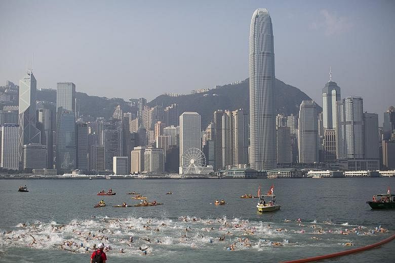 Participants in the New World Harbour Race crossing the starting line at the Tsim Sha Tsui waterfront in Hong Kong yesterday. Around 3,000 swimmers took part in the 1km race across Victoria Harbour from Tsim Sha Tsui, on the Kowloon side, to Wan Chai