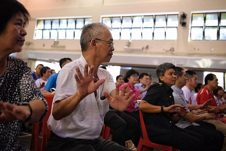 Stroke survivor Lim Huah Yong (centre) and his wife taking part in a mass exercise at Hong Kah North Community Club yesterday.