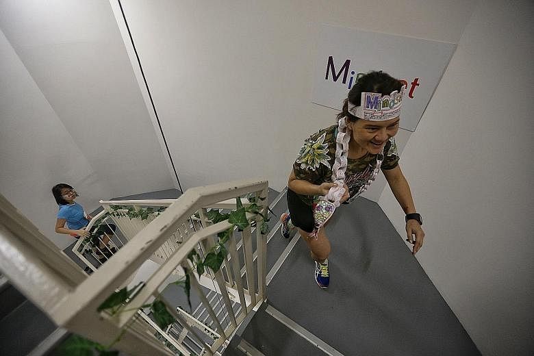 Ms Dora Chua, a receptionist with Jardine Cycle and Carriage, dressed in her jungle-themed outfit, climbing the 33 floors of Marina Bay Financial Centre Tower 1, during the Mindset Challenge and Carnival.