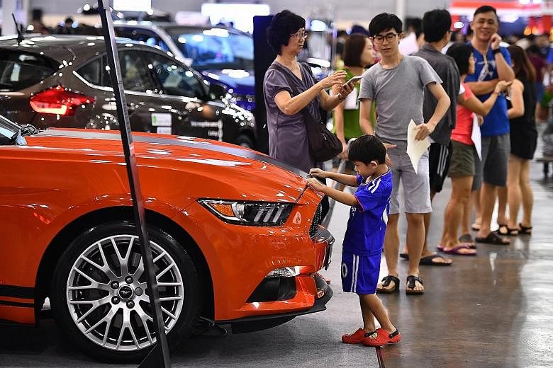 Five-year-old Jayden Goh checking out a Ford Mustang convertible at the Cars@Expo yesterday. Held over the weekend and organised by ST Classifieds, Singapore Press Holdings' automobile retail bazaar attracted more than 130,000 visitors and saw some 4