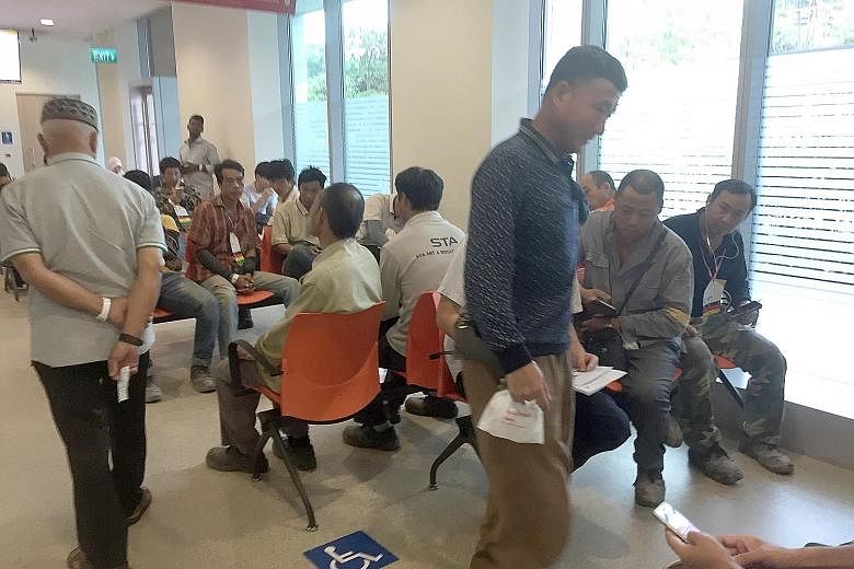 Right: Workers from South Forward Construction, who were injured in the accident yesterday, at Ng Teng Fong Hospital's accident and emergency department. Twenty-two of the workers have been discharged. One has been hospitalised, while three are under