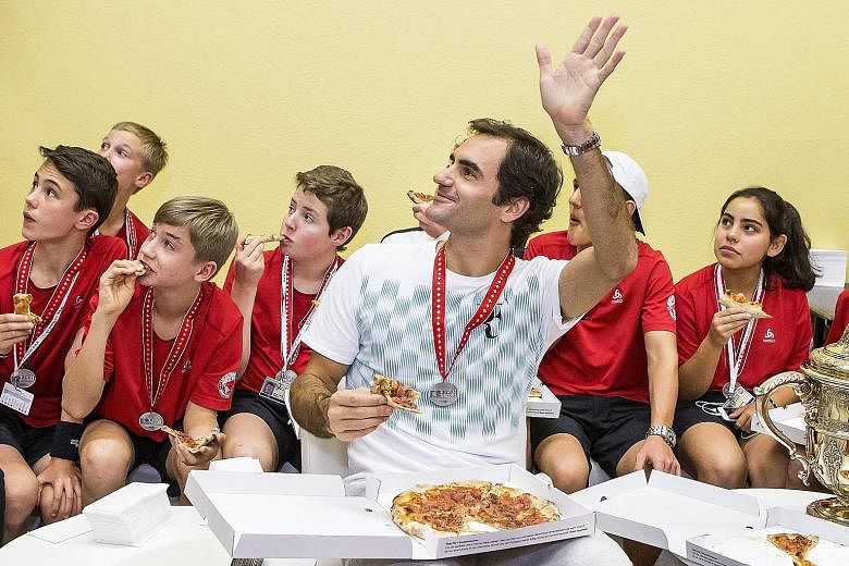 Roger Federer sharing pizza with ball kids after defeating Juan Martin del Potro to take the Basel Open for the eighth time. His withdrawal from this week's Paris Masters means Rafael Nadal should finish the year as world No. 1 for the fourth time.