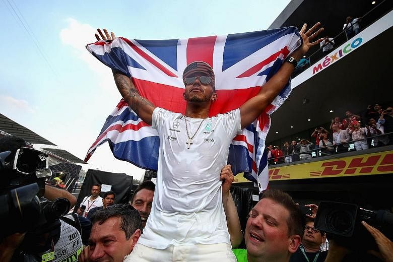 Mercedes' Lewis Hamilton celebrating with the Union Jack after winning his fourth world title despite finishing ninth in the Mexican Grand Prix on Sunday. He is now joint third on the all-time championship list.